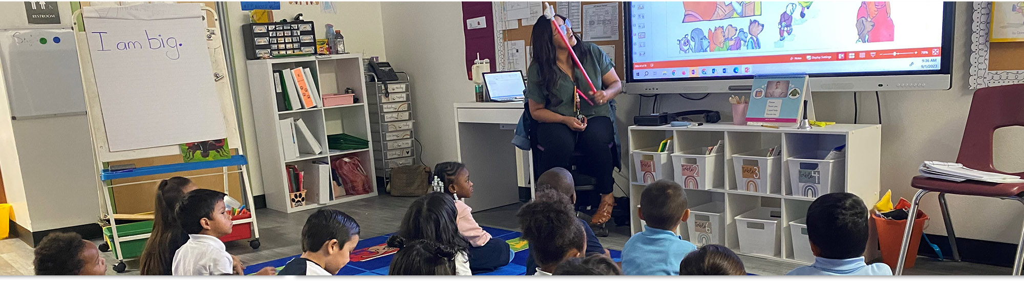 Kindergarten teacher teaching students to read